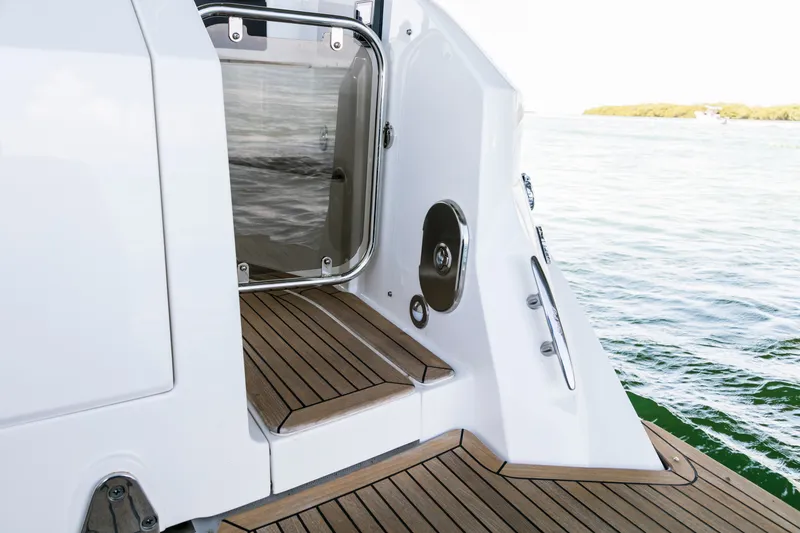 Slide: The Image of The 2021 Sea Ray Sundancer 320 Outboard features an elegant teak platform by the water. - 13