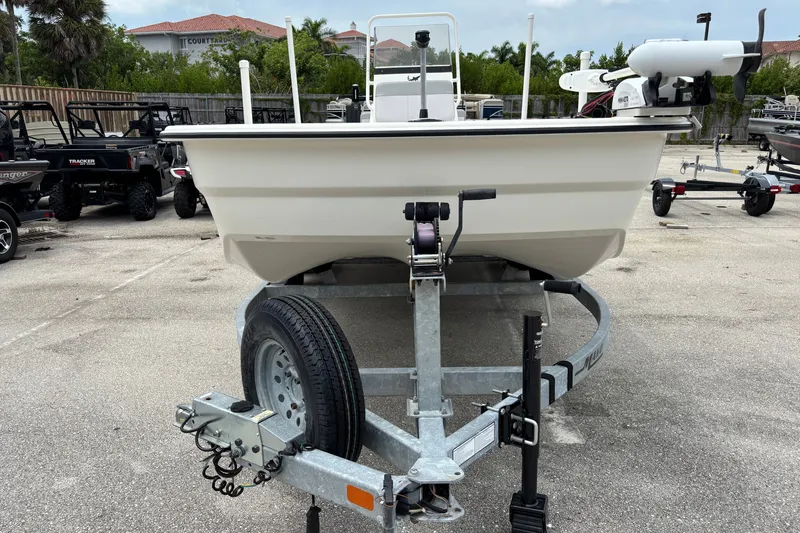 Slide: The Image of 2023 Mako Pro Skiff 19 CC on trailer, parked outdoors, showcasing front view. - 1