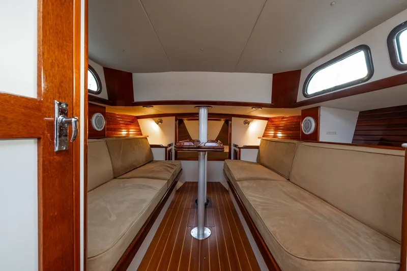 Slide: The Image of Interior of a 2005 Morris M36 sailboat with wooden finishes and beige seating. - 15