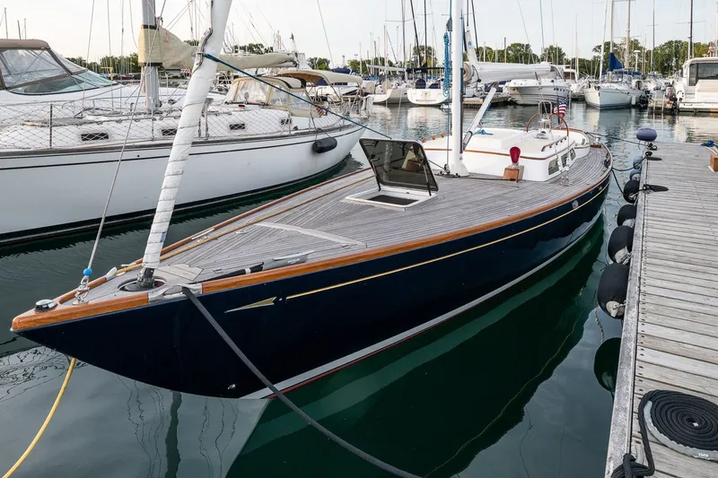 Slide: The Image of Sleek 2005 Morris M36 sailboat docked at a marina, surrounded by other vessels. - 3