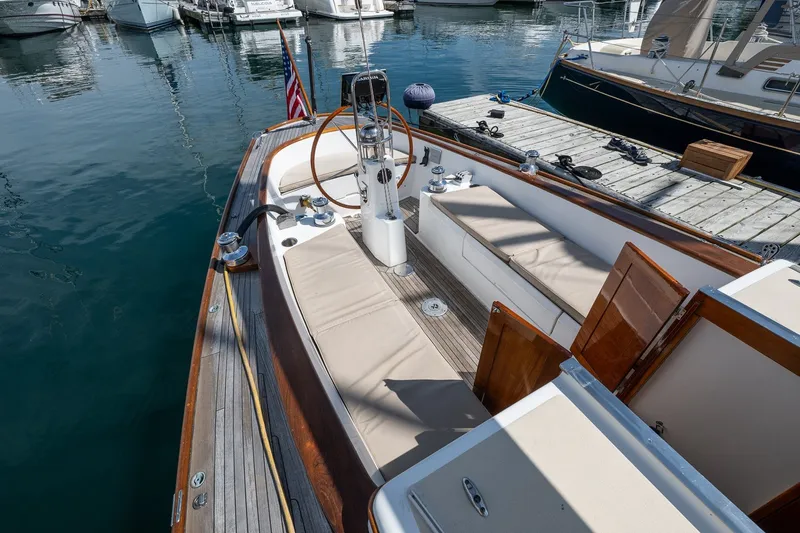 Slide: The Image of 2005 Morris M36 sailboat docked, featuring a spacious cockpit with cushioned seating. - 11