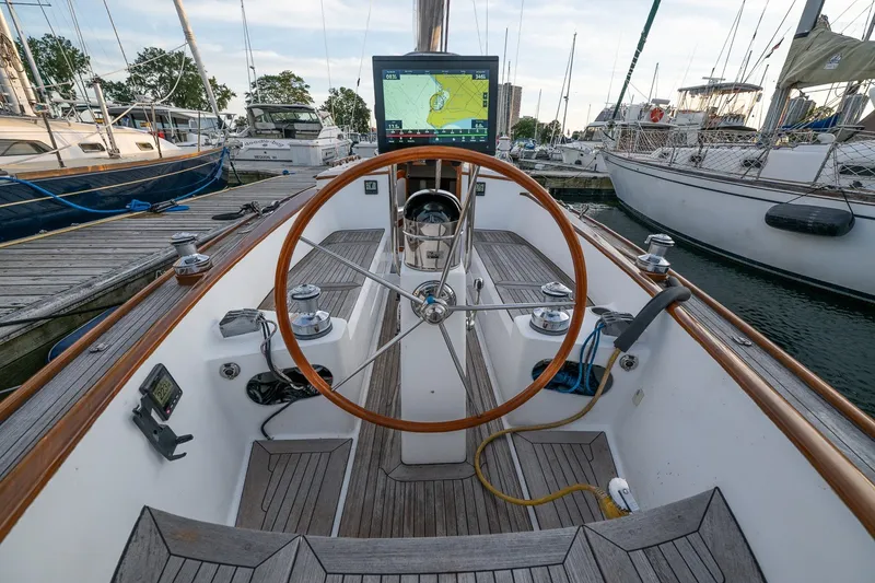 Slide: The Image of Cockpit of a 2005 Morris M36 sailboat with wooden steering wheel and navigation display. - 8
