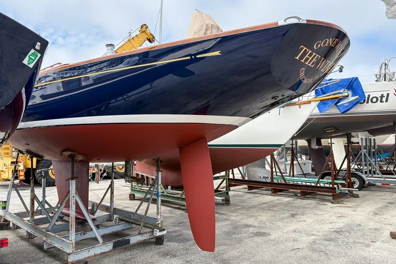 Slide: The Image of 2005 Morris M36 sailboat on stands in a boatyard, showcasing its sleek hull design. - 28