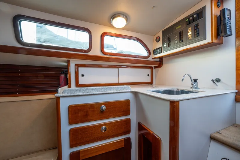 Slide: The Image of Interior of a 2005 Morris M36 sailboat galley with wood accents and modern amenities. - 19