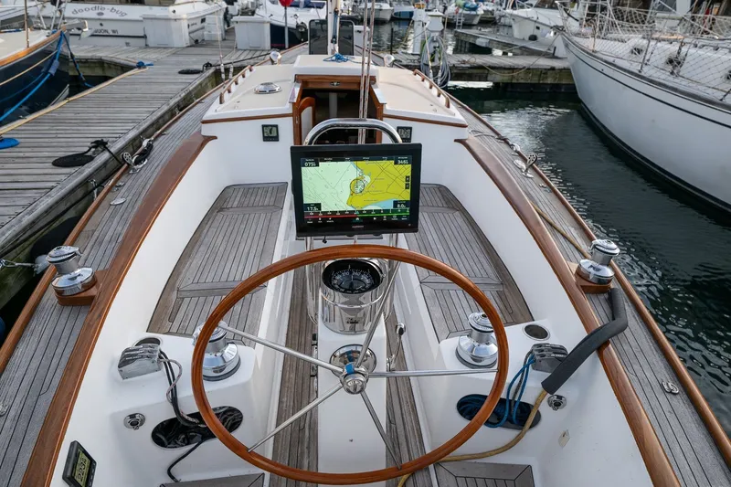 Slide: The Image of Cockpit of a 2005 Morris M36 sailboat with navigation display and wooden steering wheel. - 9
