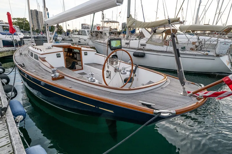 Slide: The Image of 2005 Morris M36 sailboat docked at marina, featuring elegant wooden deck and classic design. - 2