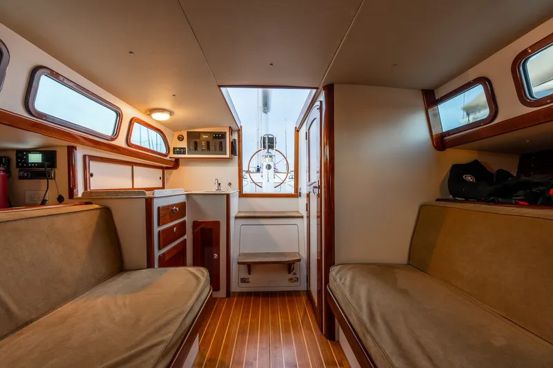 Slide: The Image of Interior of a 2005 Morris M36 sailboat, featuring cozy seating and wooden accents. - 26
