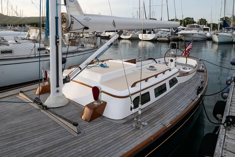 Slide: The Image of Sailboat docked in marina, Morris M36, 2005 model, with wooden deck and American flag. - 4
