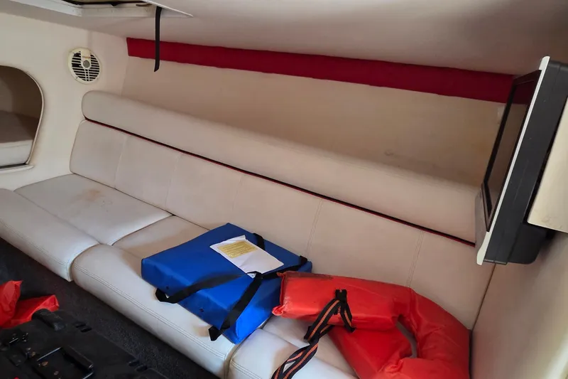 Slide: The Image of Interior of 2007 Donzi 38 ZR boat with white seating, life jackets, and a TV. - 31
