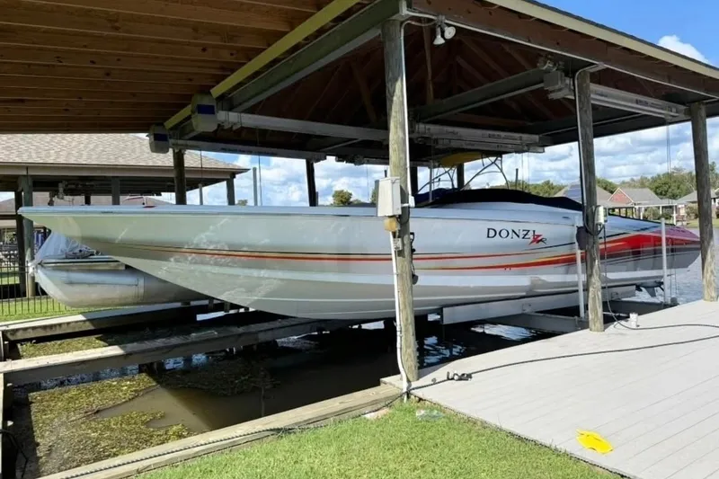 The Image of 2007 Donzi 38 ZR speedboat on lift under covered dock. - 2