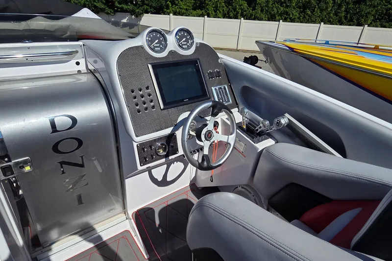 Slide: The Image of Interior of a 2007 Donzi 38 ZR speedboat, featuring a sleek dashboard and steering wheel. - 14