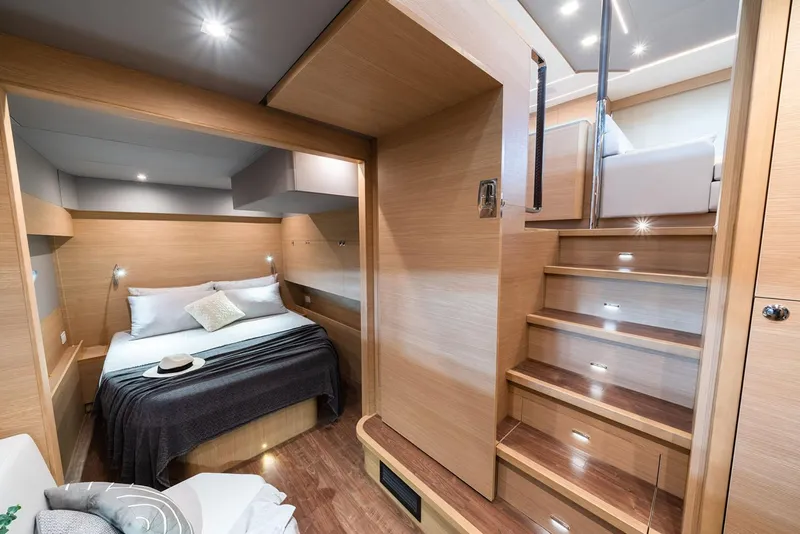 Slide: The Image of Manufacturer Provided Image: Luxurious interior of 2026 Aquila 54 Yacht featuring a cozy bedroom and elegant wooden staircase. - 14