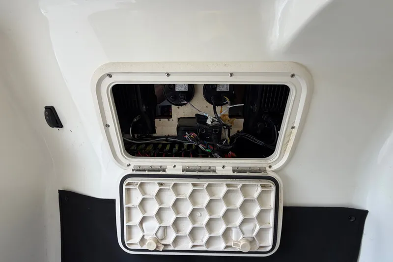 Slide: The Image of Open hatch on a 2019 Mako 284 Center Console boat, revealing internal wiring. - 27