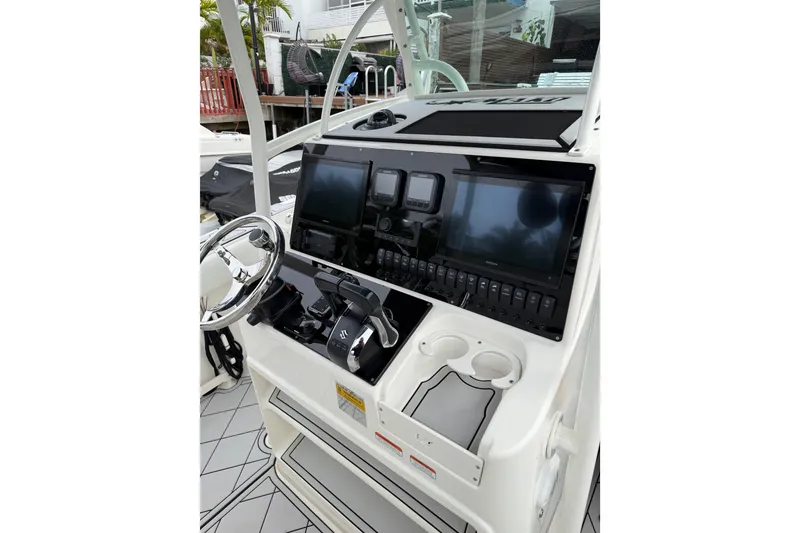 Slide: The Image of 2019 Mako 284 Center Console boat dashboard with steering wheel and electronic displays. - 13