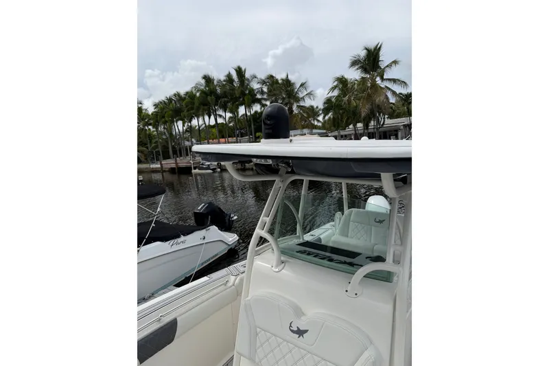 Slide: The Image of 2019 Mako 284 Center Console boat docked near palm trees. - 22
