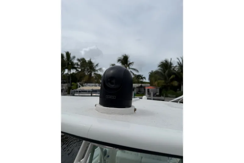 Slide: The Image of 2019 Mako 284 Center Console boat with mounted camera, palm trees in background. - 23
