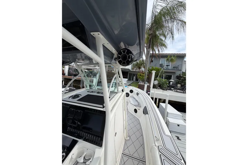 Slide: The Image of 2019 Mako 284 Center Console boat docked near a waterfront home. - 24