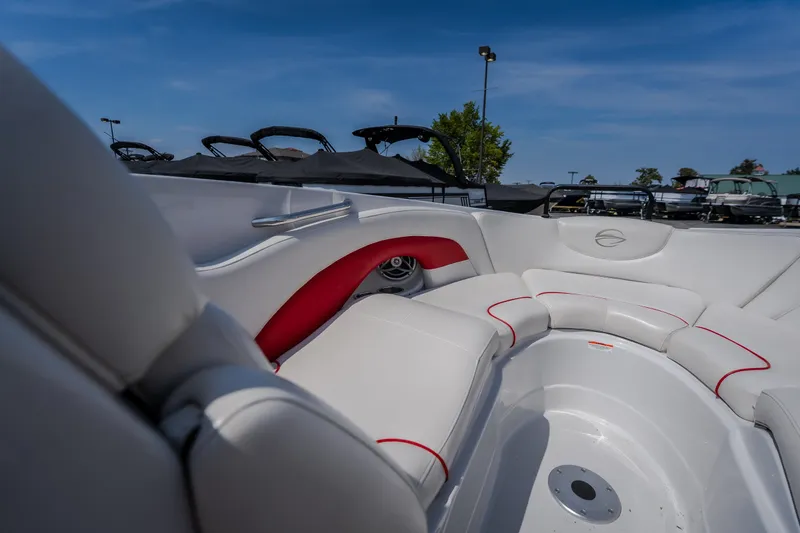 Slide: The Image of 2009 Crownline 260 LS boat interior with white and red seating under a clear blue sky. - 43