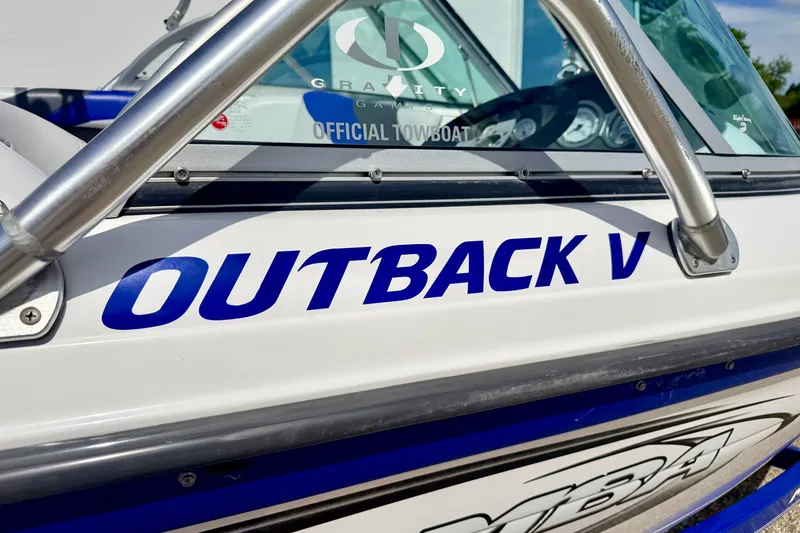 Slide: The Image of 2007 Moomba Outback V boat with blue lettering and metal railings. - 14