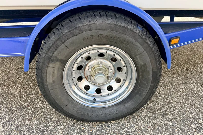 Slide: The Image of 2007 Moomba Outback V trailer wheel with ST Radial tire on asphalt. - 84