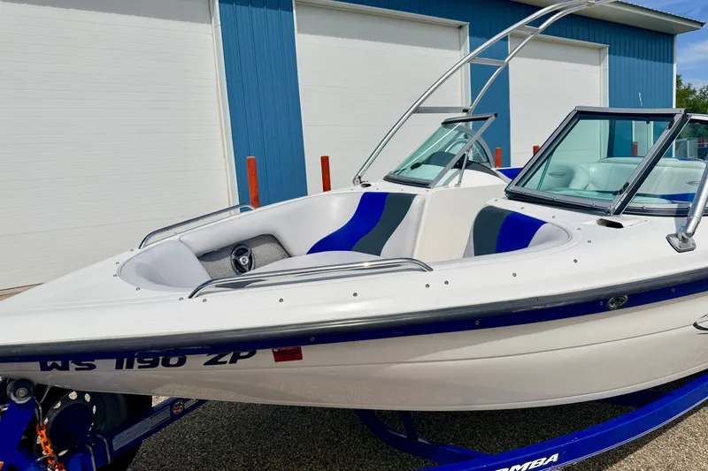 Slide: The Image of 2007 Moomba Outback V boat with blue accents, parked near a blue building. - 9