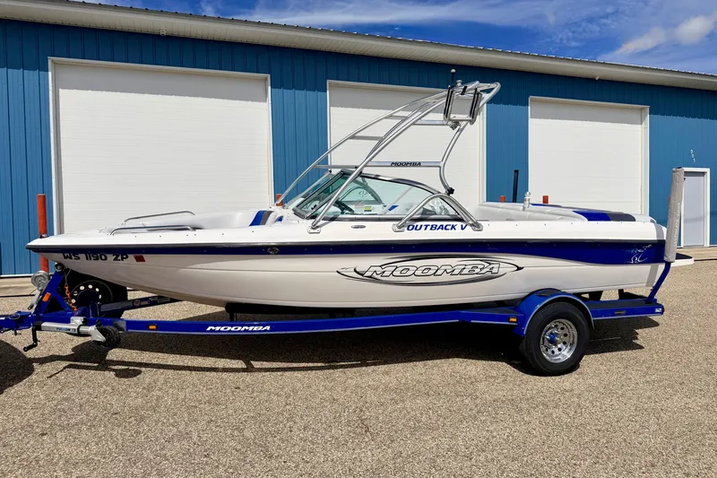 Slide: The Image of 2007 Moomba Outback V boat on trailer, parked outside blue building. - 1