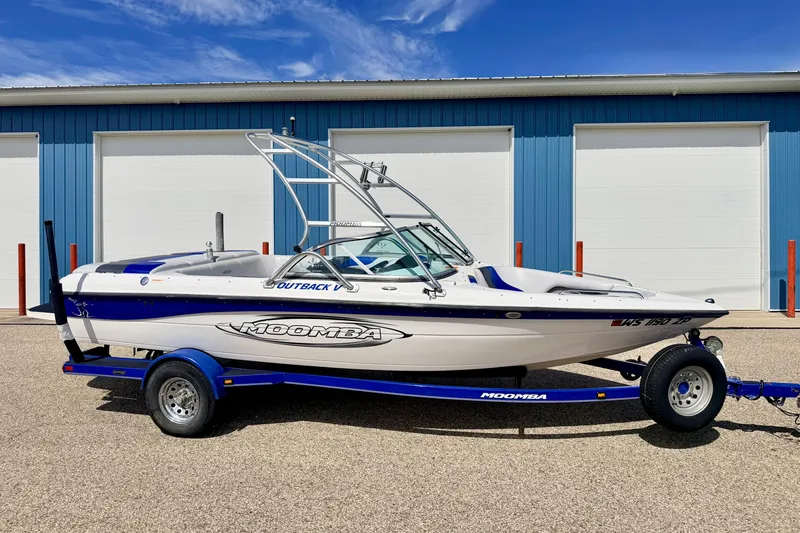 Slide: The Image of 2007 Moomba Outback V boat on trailer, parked in front of blue storage units. - 2