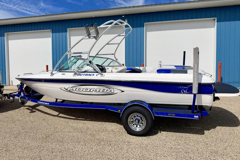 Slide: The Image of 2007 Moomba Outback V boat on trailer, parked outside blue building. - 5