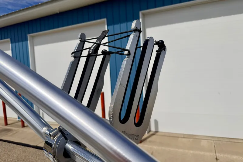 Slide: The Image of Close-up of a 2007 Moomba Outback V wakeboard rack against a blue building background. - 77
