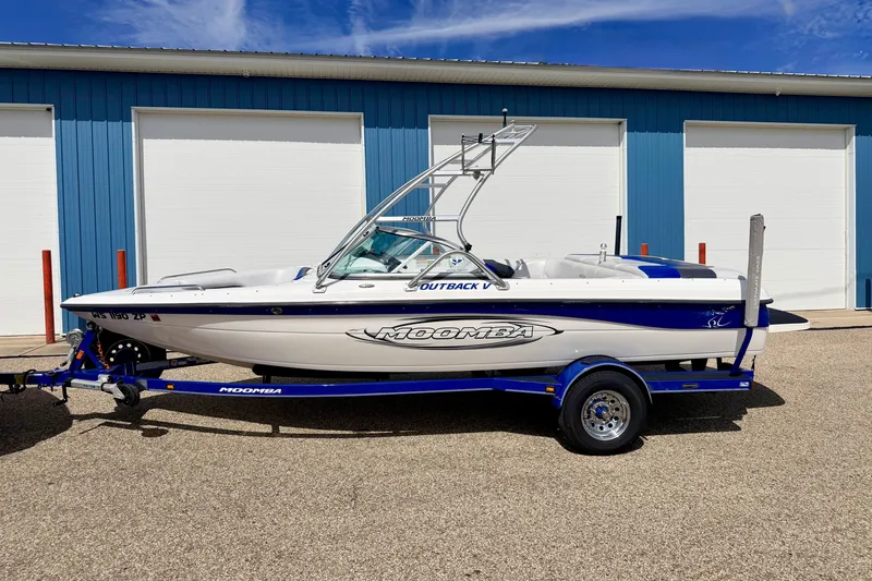 Slide: The Image of 2007 Moomba Outback V boat on trailer, parked outside blue building. - 3