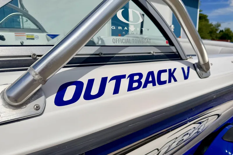 Slide: The Image of 2007 Moomba Outback V boat with blue lettering and metal railings. - 7