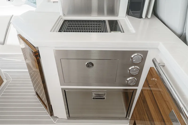Slide: The Image of The 2023 Tiara Yachts 48 LS features a sleek outdoor kitchen with a grill and refrigerator. - 26