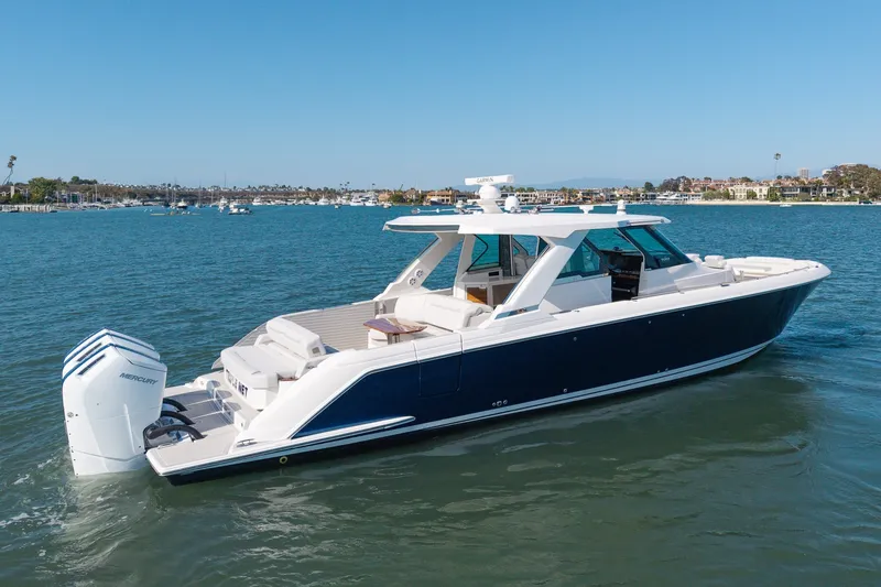 Slide: The Image of A luxurious 2023 Tiara Yachts 48 LS on calm water, featuring sleek design and powerful outboard engines. - 1