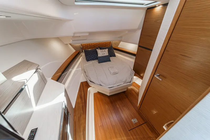 Slide: The Image of The 2023 Tiara Yachts 48 LS cabin features a sleek bed and wooden accents. - 45