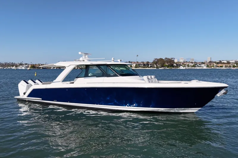 Slide: The Image of A luxurious 2023 Tiara Yachts 48 LS on calm water with a blue hull. - 2