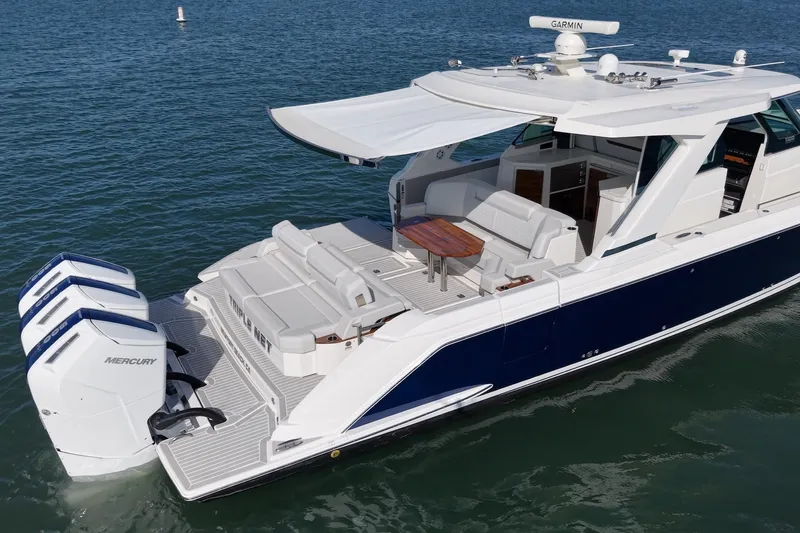 Slide: The Image of 2023 Tiara Yachts 48 LS with triple outboard engines, spacious deck, and luxurious seating area. - 8