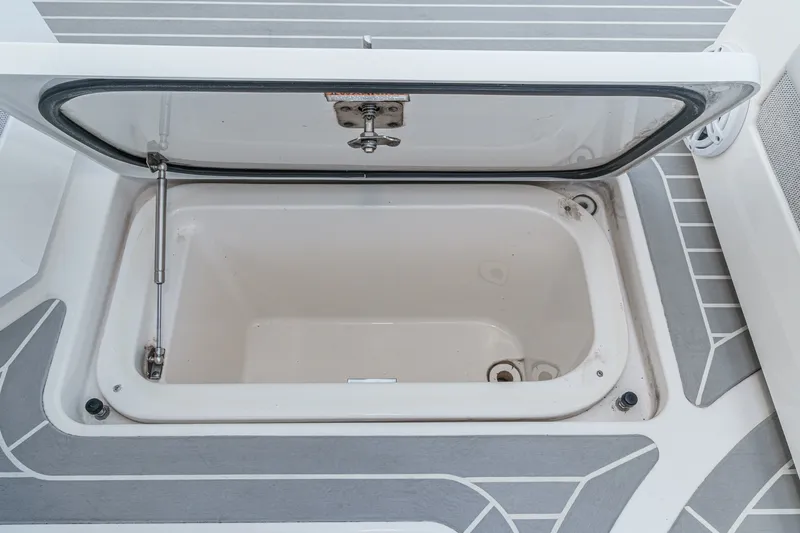 Slide: The Image of An open storage compartment on a boat with gray and white flooring. - 43