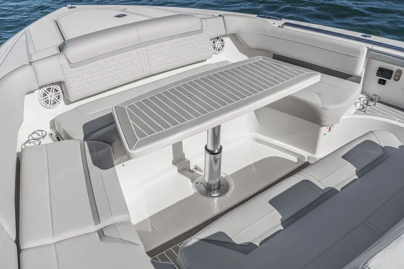 Slide: The Image of Luxurious seating area with a table on a Tiara Yachts 48 LS, surrounded by water. - 13