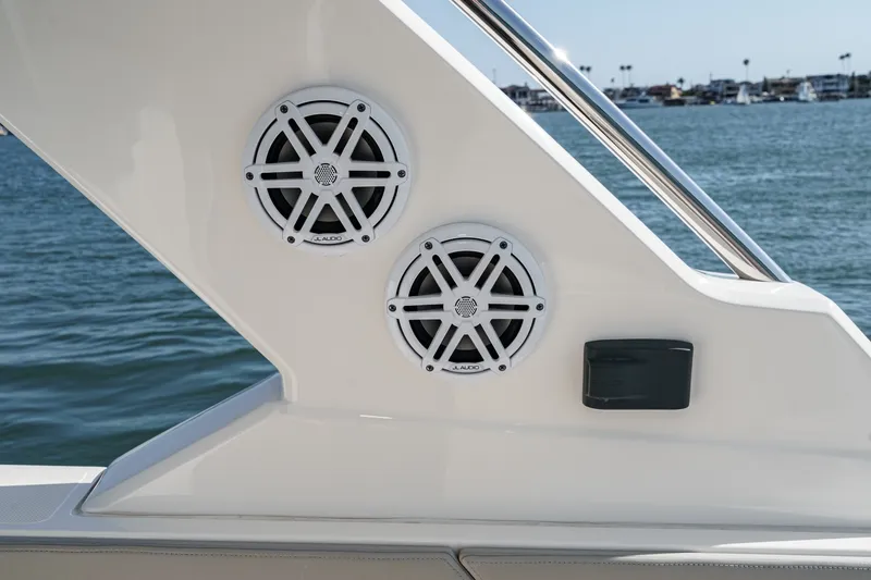 Slide: The Image of Two speakers are mounted on a white boat wall, with water in the background. - 38