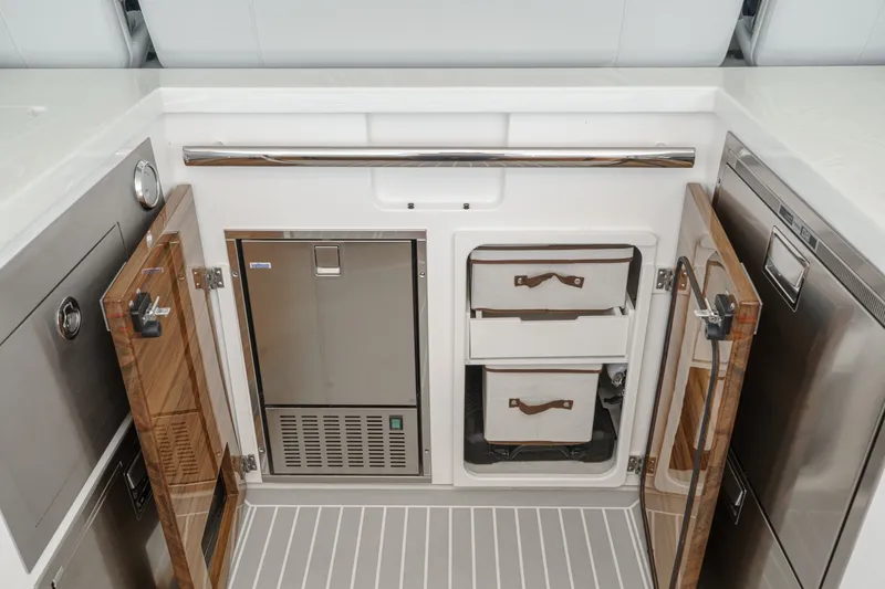 Slide: The Image of The galley of a 2023 Tiara Yachts 48 LS features cabinets and stainless steel appliances. - 28