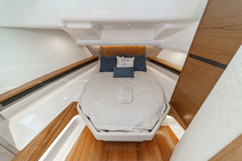 Slide: The Image of The cabin of a 2023 Tiara Yachts 48 LS with a cozy bed and wood accents. - 46