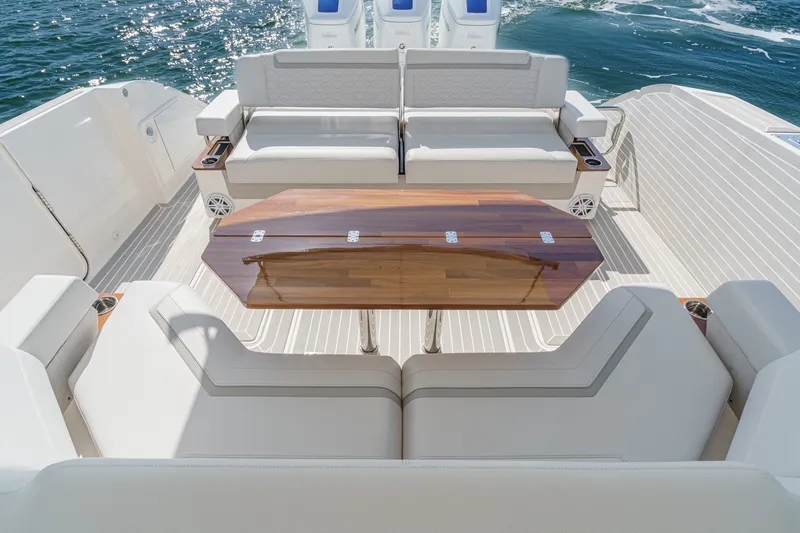 Slide: The Image of The image shows the aft deck of a 2023 Tiara Yachts 48 LS with elegant seating and a wooden table. - 21
