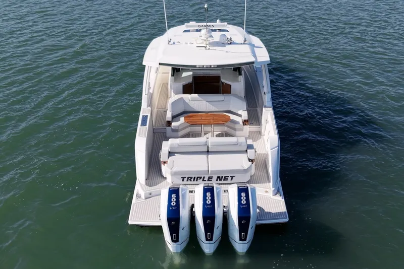 Slide: The Image of The 2023 Tiara Yachts 48 LS is a luxury boat with triple outboard engines and a sleek deck. - 3