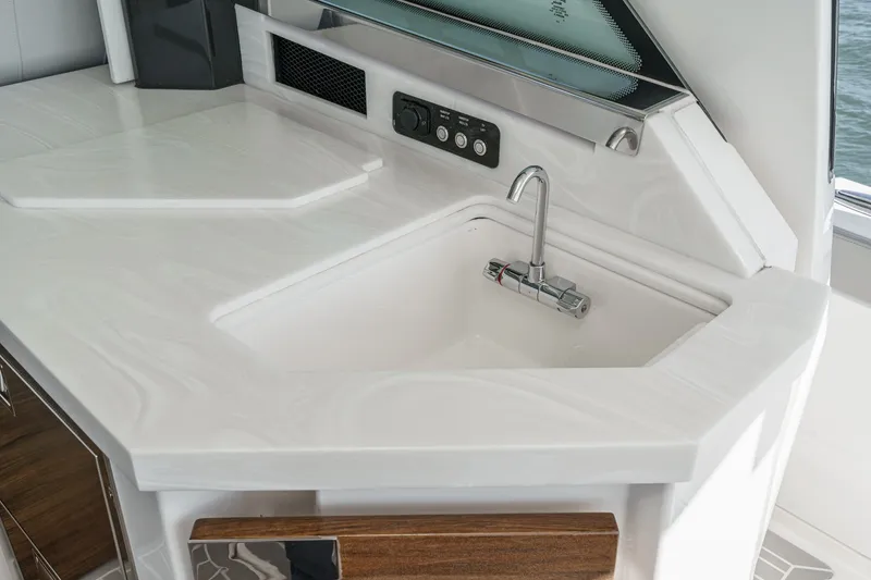 Slide: The Image of A modern kitchenette with a white countertop and integrated sink on a yacht. - 30