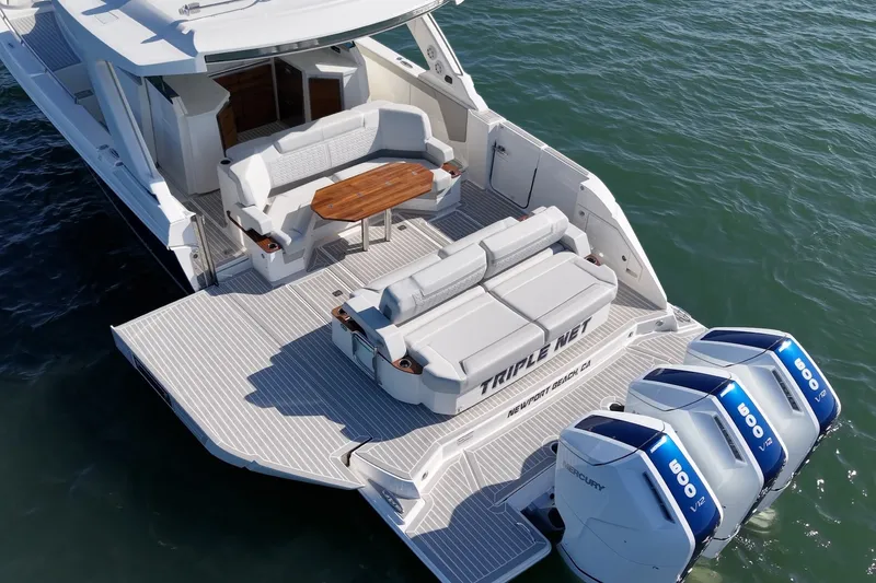 Slide: The Image of The image shows the stern of a 2023 Tiara Yachts 48 LS with three outboard engines. - 9