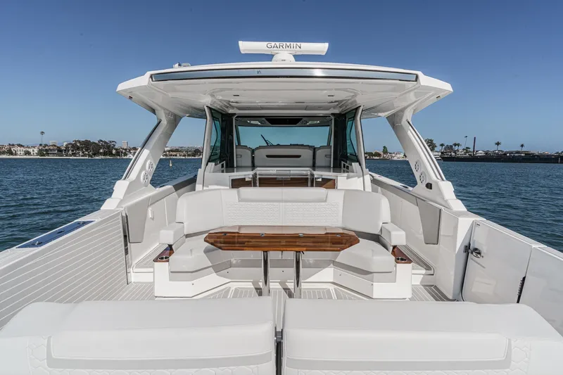 Slide: The Image of The 2023 Tiara Yachts 48 LS features a sleek, modern design with spacious seating and a wooden table. - 17