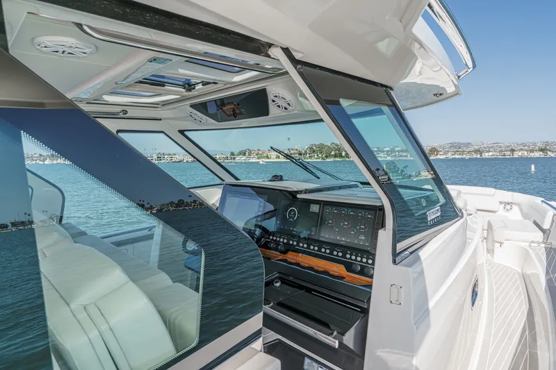 Slide: The Image of The cockpit of a 2023 Tiara Yachts 48 LS with modern instruments and panoramic views. - 35