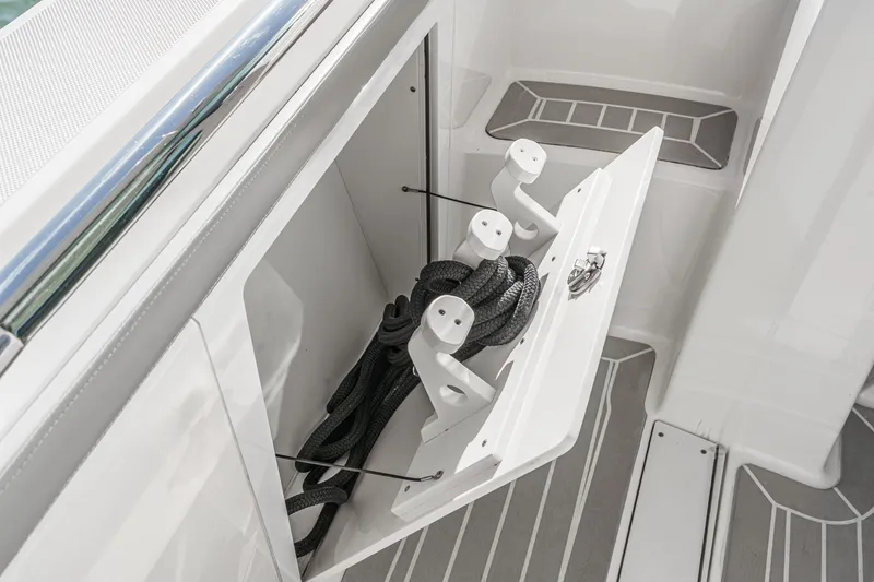 Slide: The Image of An open storage compartment on a 2023 Tiara Yachts 48 LS with ropes and holders. - 39