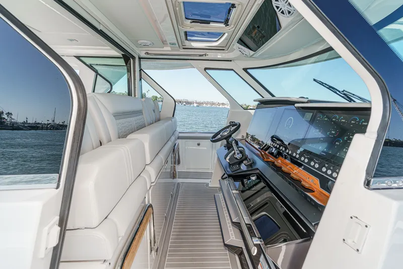 Slide: The Image of The image shows the cockpit of a 2023 Tiara Yachts 48 LS with luxurious seating and modern controls. - 36