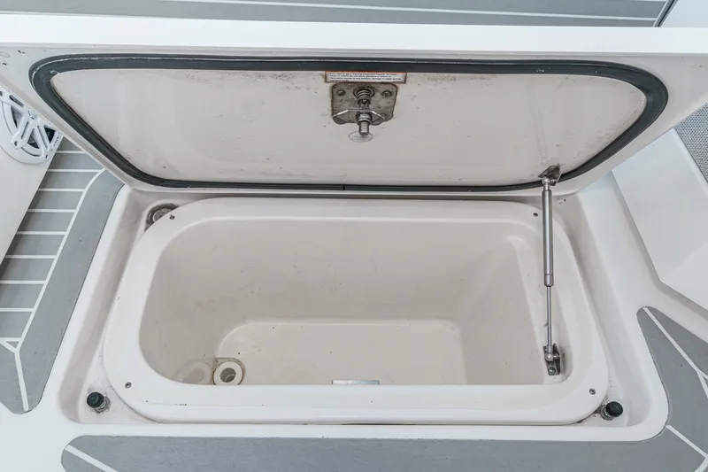 Slide: The Image of An open storage compartment on a boat with gray flooring. - 44